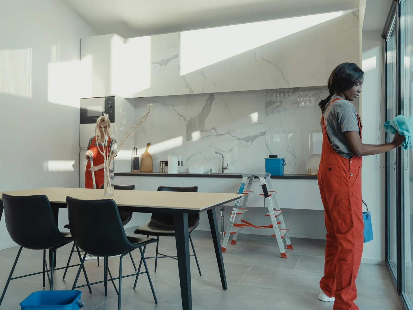 Cleaning team wiping down tables and windows in a bright, open workspace