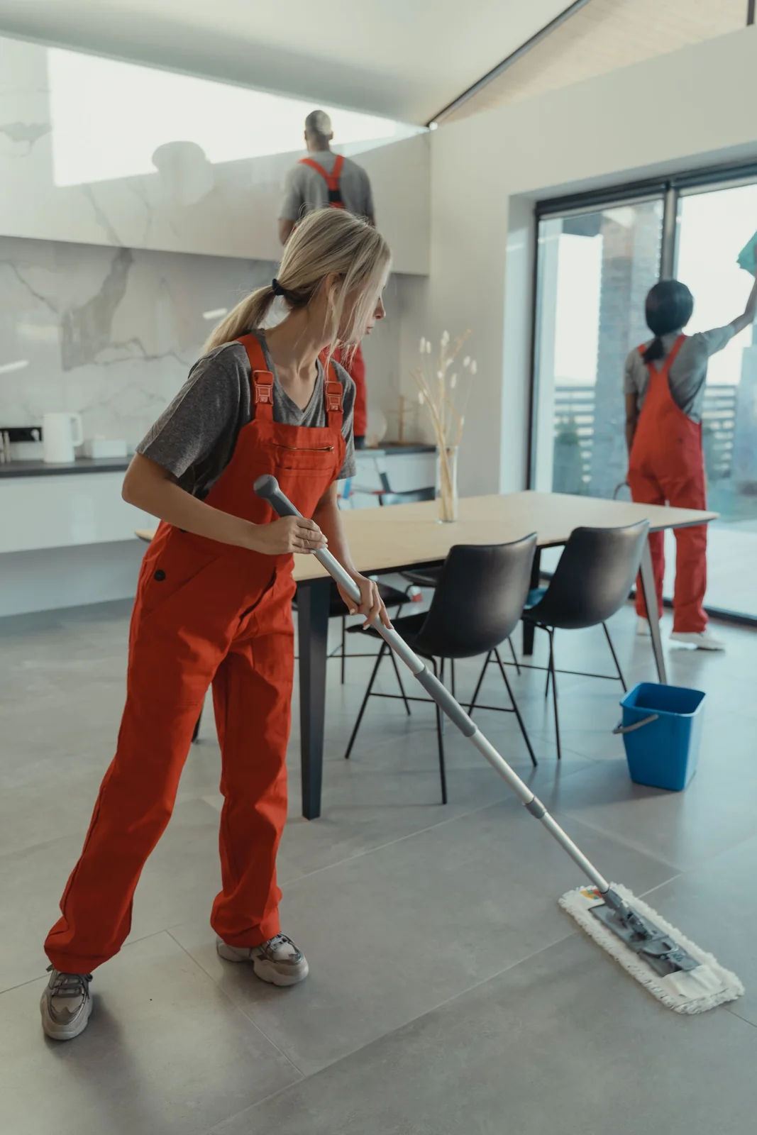 Cleaning team mopping floors and wiping surfaces in a dining area