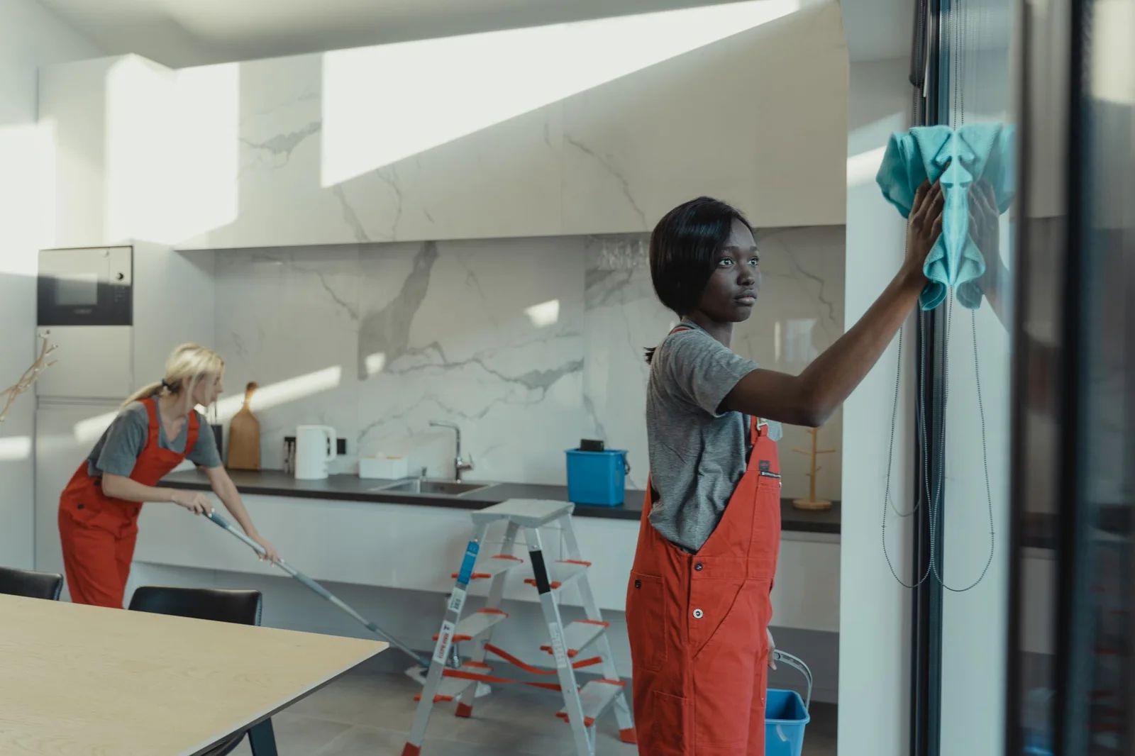 Crew wiping down glass panels and counters in a modern space